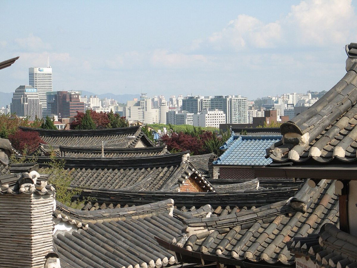 Curved clay-tile roofs and eaves of neighboring hanok houses in Bukchon Hanok Village, Seoul.