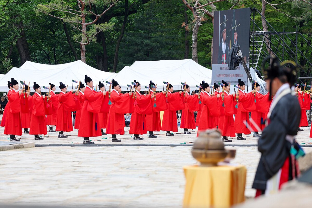 Officiants in red ritual robes line up before the shrine hall during the Jongmyo Jerye royal ancestral rite.