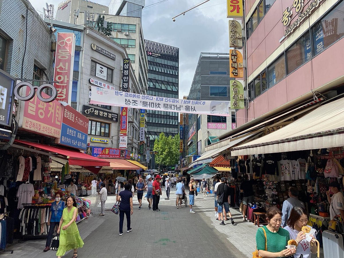 Stalls and shoppers along a busy street of Namdaemun Market in central Seoul.