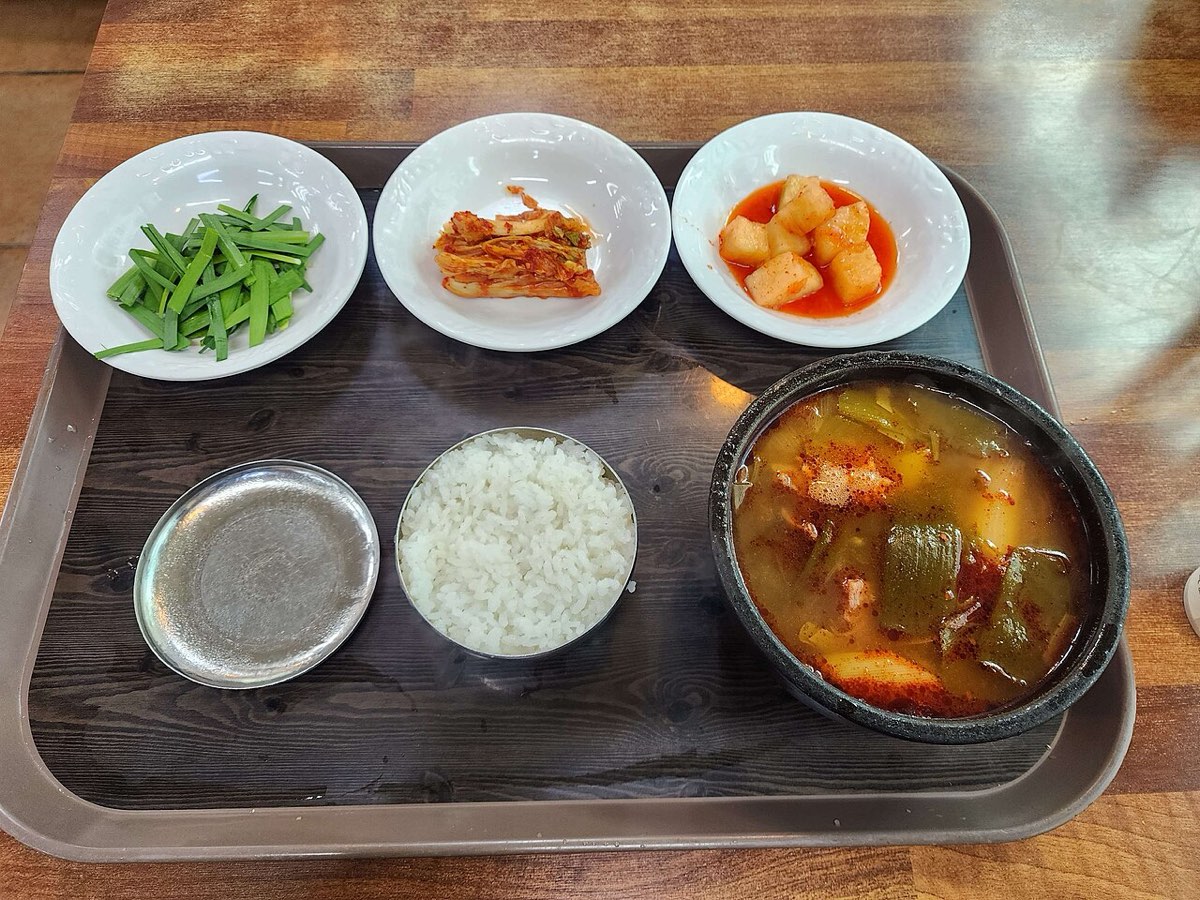 A one-person tray of ttaro gukbap, with the soup, a separate bowl of rice and side dishes.