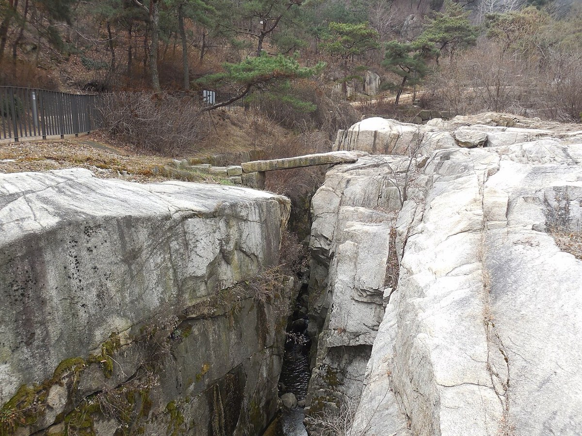 Giringyo, a Joseon-era stone slab bridge, crossing the rocky stream bed of Suseongdong Valley in Seochon.
