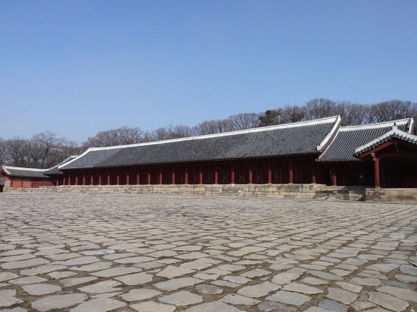 The long, low main hall of Jongmyo Shrine behind its wide stone terrace